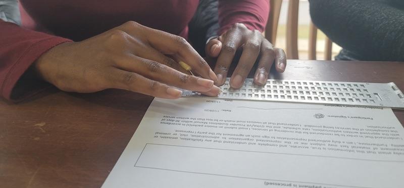 Image of a teacher and student's hands learning braille.