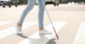 a pair of feet crossing the street at a crosswalk while using a white cane